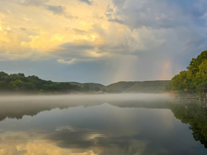 Rain clouds just south of Lake Austin over calm foggy water