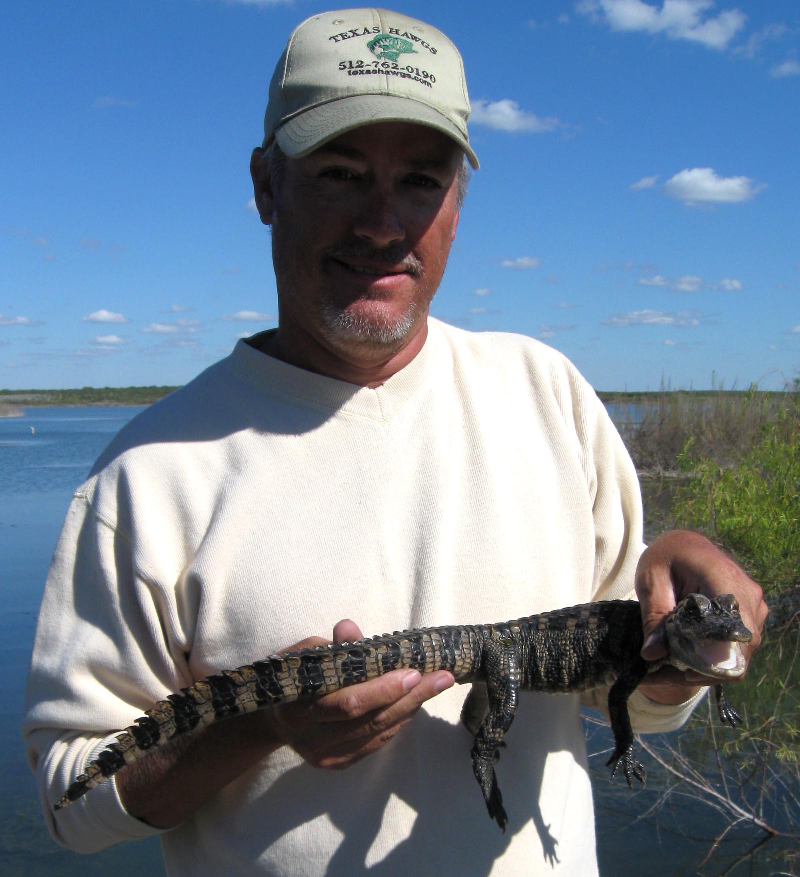 Guide holding a small alligator at Choke Canyon Reservoir, November 2010