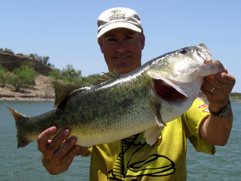 Angler holding a Lake Falcon bass on the front deck, July 2009