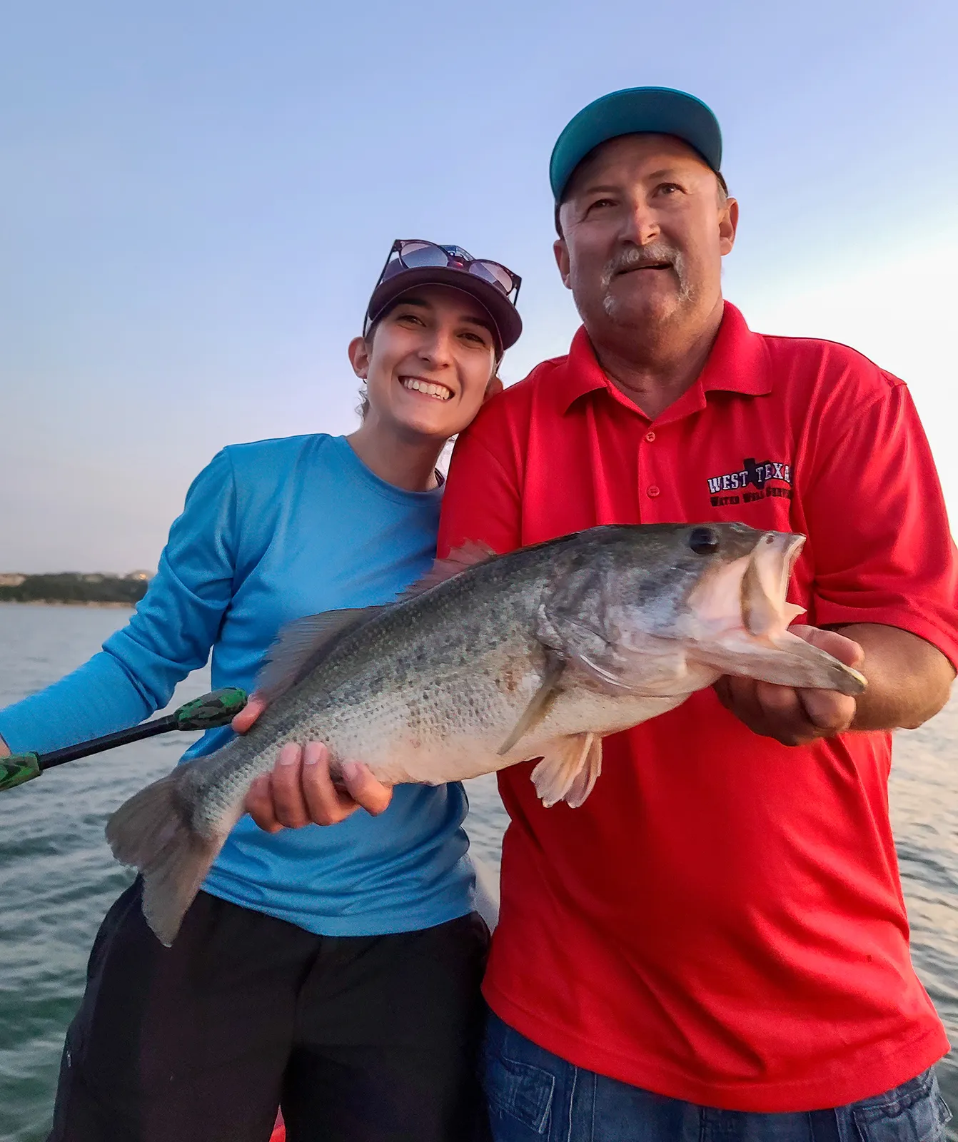 Two anglers with a big bass at sunset on a Texas Hawgs trip